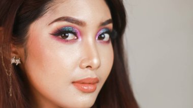 Renkli makyajlı güzel bir kızın yakın plan portresi.
