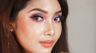 Renkli makyajlı güzel bir kızın yakın plan portresi.