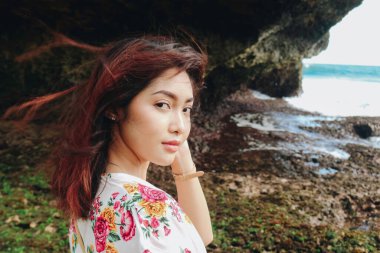 Sahilde genç bir Asyalı kız Gunungkidul, Endonezya 'da kameraya bakıyor.