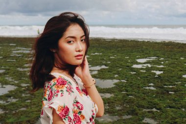 Sahilde genç bir Asyalı kız Gunungkidul, Endonezya 'da kameraya bakıyor.