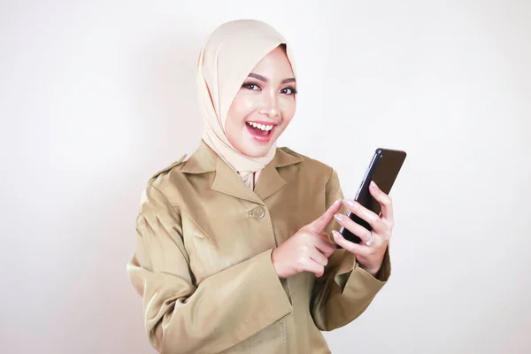 スマートフォンに空白の画面を表示する政府の労働者笑顔 カーキ色の制服とヒジャーブを着た若いアジア系ムスリムPns — ストック写真