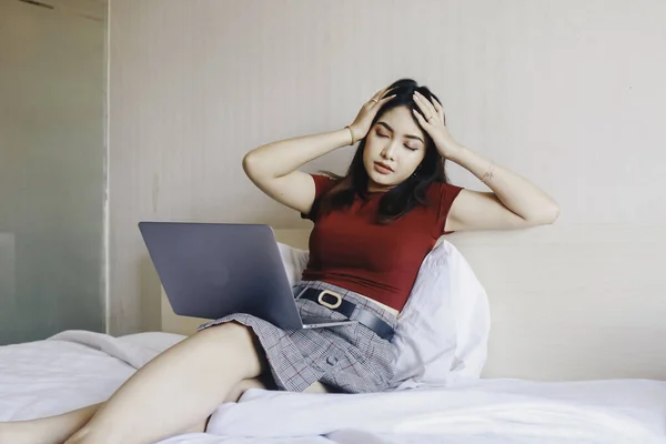 Depressed desperate businesswoman looking frustrated being overworked sitting on bed