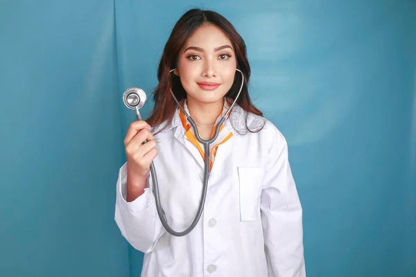 一位年轻的亚洲女医生的画像 一位医学专业人员面带微笑 带着听诊器 与蓝色背景隔离 — 图库照片