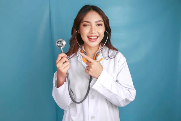 一位年轻的亚洲女医生的画像 一位医学专业人员面带微笑 带着听诊器 与蓝色背景隔离 — 图库照片