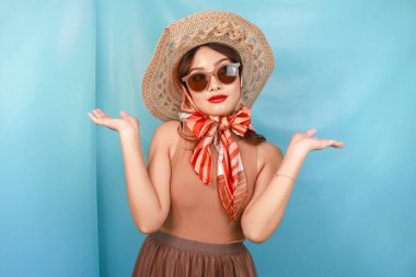 Genç Asyalı mutlu bir kadının seyahat konsepti mavi bir arka planla izole edilmiş.