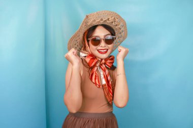 Genç Asyalı kendine güvenen ve mutlu bir kadın mavi bir geçmişle izole edilmiş..