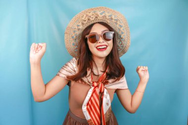 Genç Asyalı kendine güvenen ve mutlu bir kadın mavi bir geçmişle izole edilmiş..