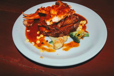 Bir tabak tavuk, biftek ve sosis.