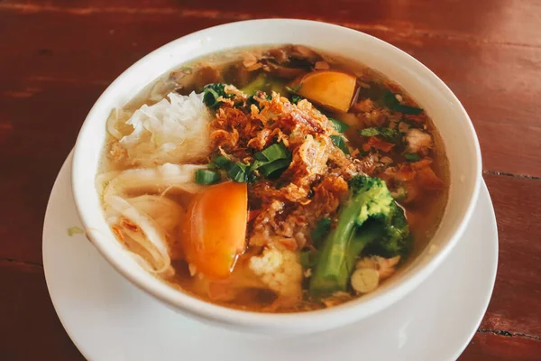 Ahşap masada bir kase mantar çorbası portresi.