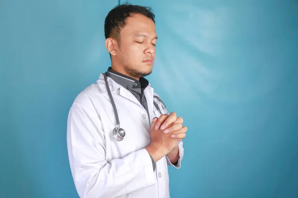 若いアジアの男性医師の肖像画は神に祈っています — ストック写真