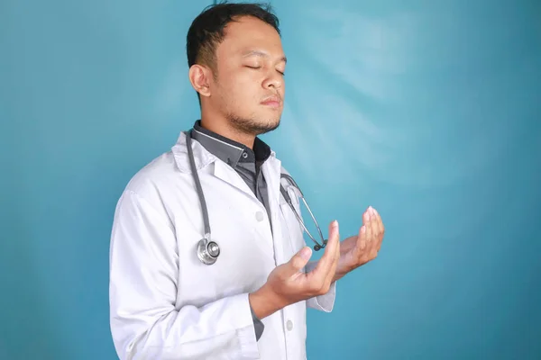 一个年轻的亚洲男医生的画像正在向上帝祈祷 — 图库照片
