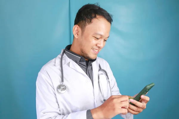 Joven Asiático Hombre Médico Está Sonriendo Señalando Teléfono Inteligente —  Fotos de Stock