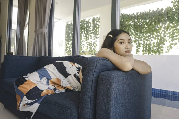 Young Asian Woman Sitting Couch Living Room Looks Sorrowful — Stockfoto