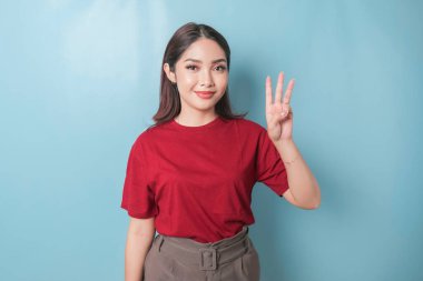 Excited Asian woman wearing a red t-shirt giving number 12345 by hand gesture