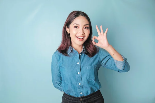 Excited Asian Woman Wearing Blue Shirt Giving Hand Gesture Isolated — ストック写真