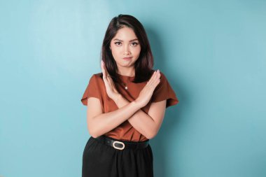 Beautiful Asian woman with hand gesture pose rejection or prohibition with copy space