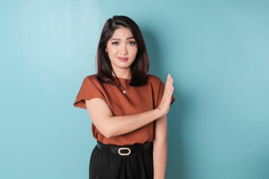 Beautiful Asian woman with hand gesture pose rejecting offer with copy space