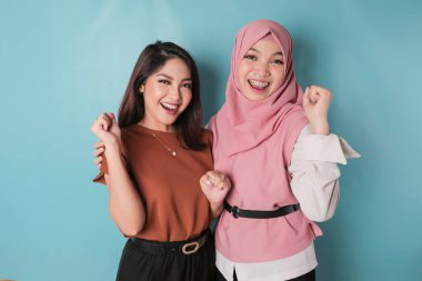 Young Asian women with a happy successful expression isolated by a blue background. friendship concept