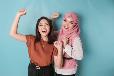 Young Asian women with a happy successful expression isolated by a blue background. friendship concept