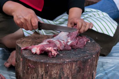 A portrait of Muslims cutting meat on Eid Al Adha by using cutting knife