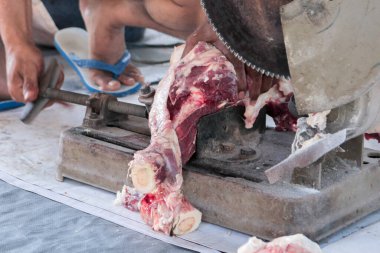 A portrait of Muslims cutting meat on Eid Al Adha by using cutting machine