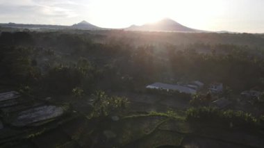 Sunrise over hillside with long sun rays pass through valley in village Bali, Indonesia