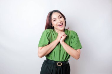 Beyaz arka planda izole edilmiş yeşil tişört giyen mutlu bir Asyalı kadının portresi