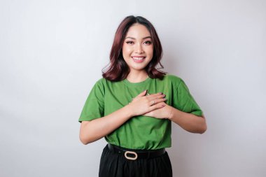 Mutlu, düşünceli, genç bir kadın, beyaz arka planda yalnız gülümsüyor.