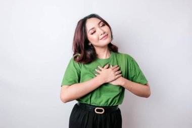 Mutlu, düşünceli, genç bir kadın, beyaz arka planda yalnız gülümsüyor.