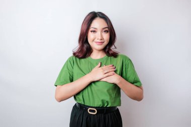 Mutlu, düşünceli, genç bir kadın, beyaz arka planda yalnız gülümsüyor.