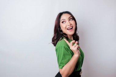 Gülümseyen güzel Asyalı kadın boş bir alanı işaret ediyor izole beyaz arka plan