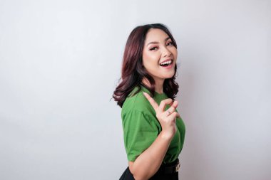 Gülümseyen güzel Asyalı kadın boş bir alanı işaret ediyor izole beyaz arka plan