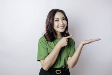 Gülümseyen güzel Asyalı kadın boş bir alanı işaret ediyor izole beyaz arka plan