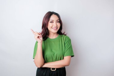 Gülümseyen güzel Asyalı kadın boş bir alanı işaret ediyor izole beyaz arka plan