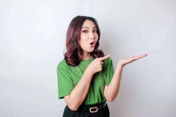 Geschokt Aziatische Vrouw Dragen Groene Shirt Wijzend Kopieerruimte Naast Haar — Stockfoto