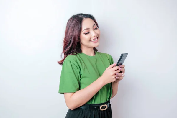 Портрет Щасливої Азіатки Посміхається Тримає Свій Смартфон Зеленій Футболці Ізольованій — стокове фото