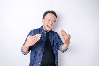 Asyalı yakışıklı, soyutlanmış beyaz arka planda genç bir adam davet ediyor. Gelmene sevindim.