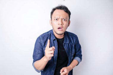 Şok olmuş Asyalı bir adamın portresi, lacivert gömlek giyiyor, beyaz bir arka planla izole edilmiş.