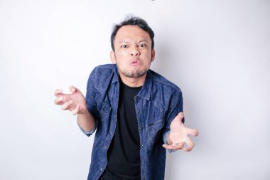 Tatmin olmamış Asyalı genç bir adam, mavi denizci gömleği giymiş, asık surat ifadeleri takınarak huysuz görünür.