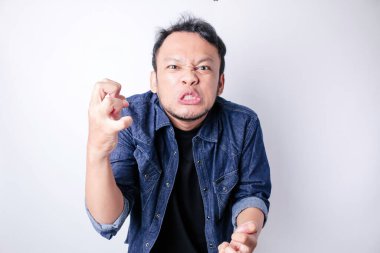 Tatmin olmamış Asyalı genç bir adam, mavi denizci gömleği giymiş, asık surat ifadeleri takınarak huysuz görünür.