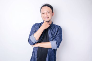 Düşünceli genç Asyalı bir adamın portresi lacivert gömlek giyiyor ve seçenekleri gözden kaçırıyor.