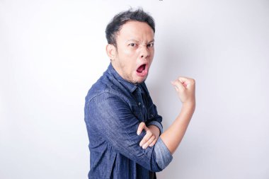 Heyecanlı Asyalı adam kollarını ve kaslarını gururla kaldırarak güçlü bir hareket sergiliyor.