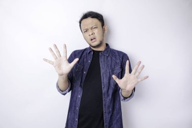 Asyalı genç adam beyaz arka planda izole edildi parmakları korkmuş ve gergindi..