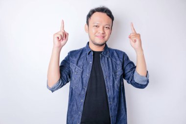Gülümseyen yakışıklı Asyalı adam boş alanı işaret ediyor izole edilmiş beyaz arka plan
