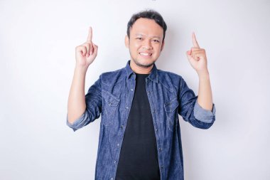 Gülümseyen yakışıklı Asyalı adam boş alanı işaret ediyor izole edilmiş beyaz arka plan