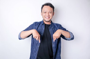 Gülümseyen yakışıklı Asyalı adam boş alanı işaret ediyor izole edilmiş beyaz arka plan