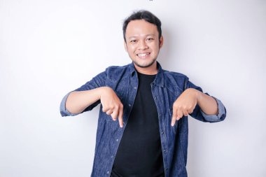 Gülümseyen yakışıklı Asyalı adam boş alanı işaret ediyor izole edilmiş beyaz arka plan