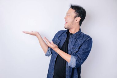 Gülümseyen yakışıklı Asyalı adam boş alanı işaret ediyor izole edilmiş beyaz arka plan