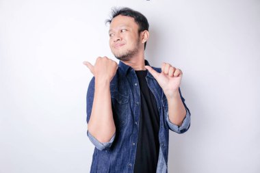 Gülümseyen yakışıklı Asyalı adam boş alanı işaret ediyor izole edilmiş beyaz arka plan