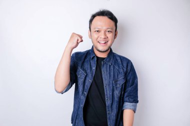 Mutlu ve başarılı bir yüzü olan, lacivert gömlekli genç bir Asyalı beyaz arka planda izole edilmiş.